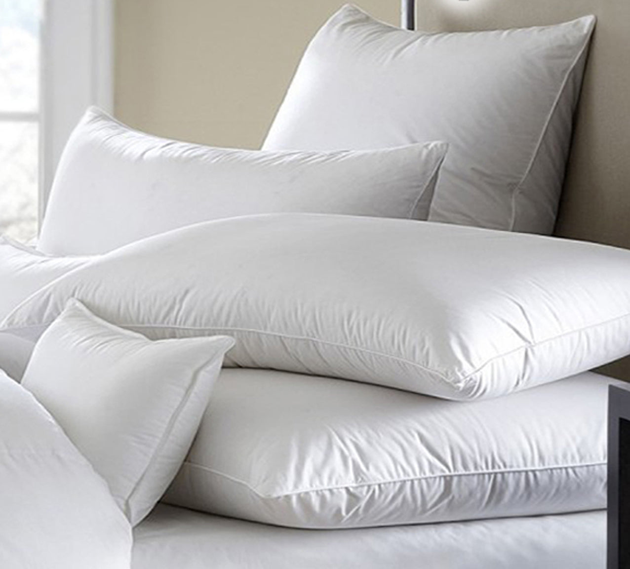 White pillows on a bed with a neutral headboard